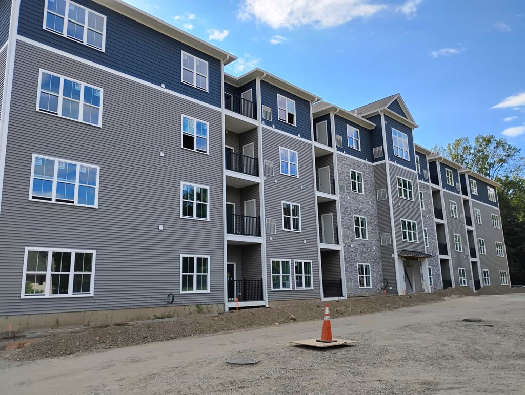 A large building with multiple balconies and windows is under construction.