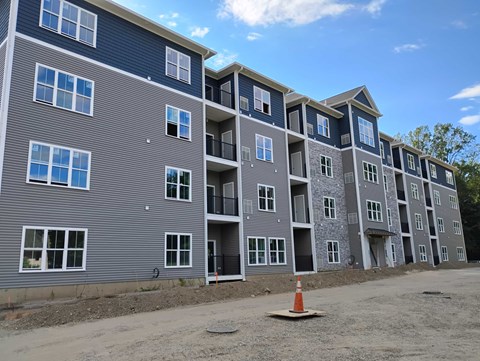 A large building with multiple balconies and windows is under construction.