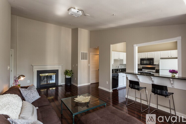 A living room with a fireplace and a glass coffee table.