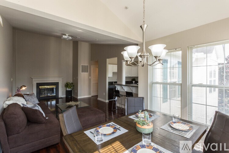 A modern living room with a fireplace and a dining table set for two.
