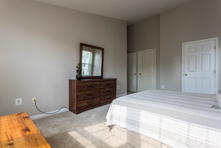 A bedroom with a bed, dresser, and mirror.