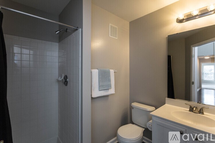 A bathroom with a toilet, sink, and shower.