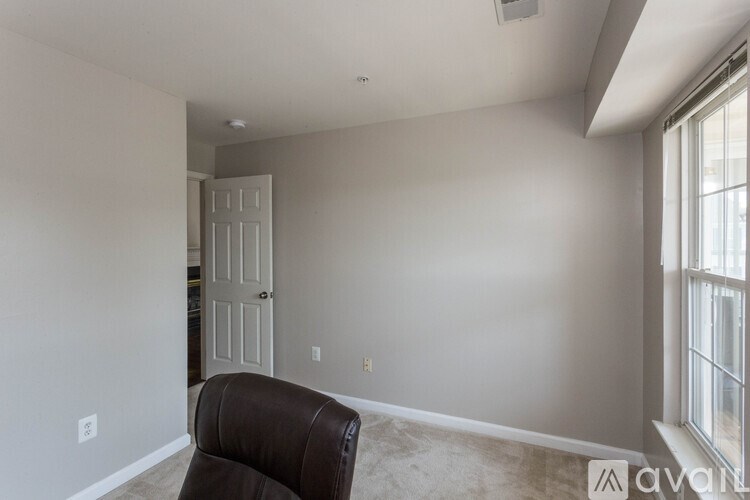 A room with a brown chair and a white door.