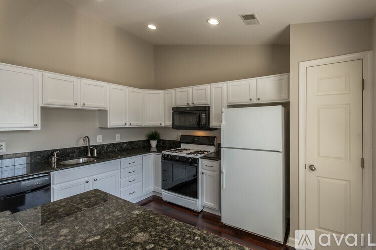 A kitchen with white cabinets and appliances.