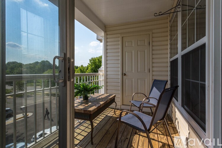 A balcony with a table and two chairs is shown.