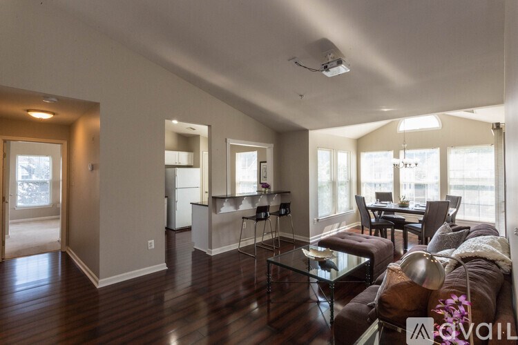 A living room with a couch, chairs, and a dining table.