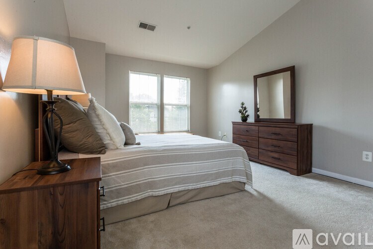 A bedroom with a bed, nightstand, and a lamp.