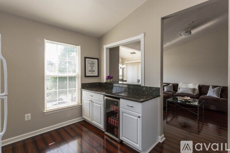 A kitchen with a granite countertop and a fridge with a glass door.