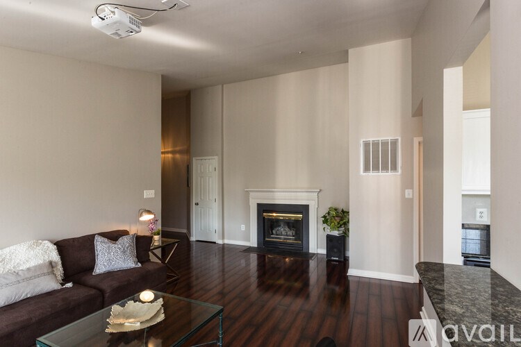 A modern living room with a fireplace and a glass coffee table.