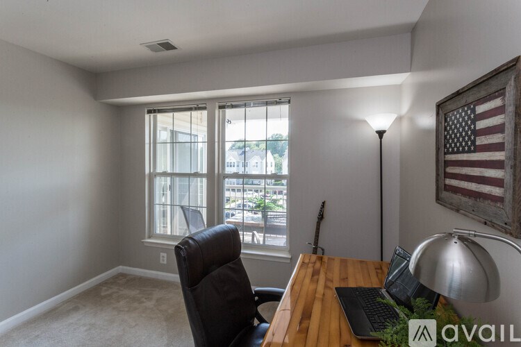 A room with a desk, chair, and a window overlooking a city street.