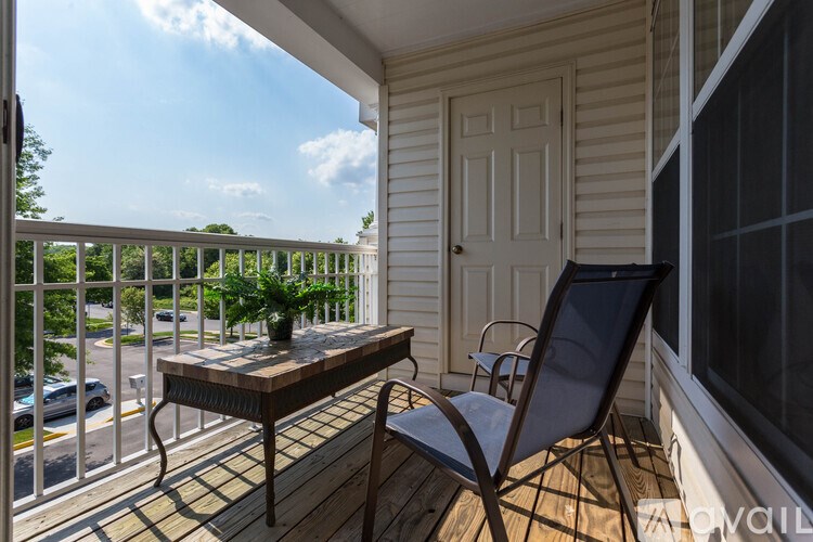 A balcony with a table and chairs overlooking a street.