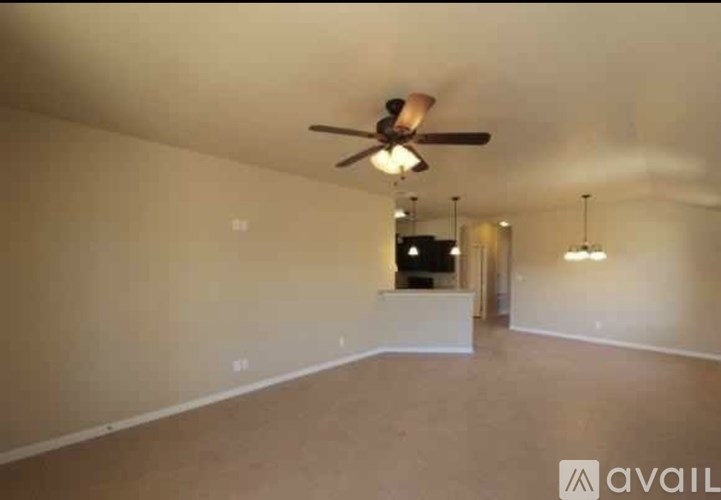A spacious room with a ceiling fan and a hanging light fixture.