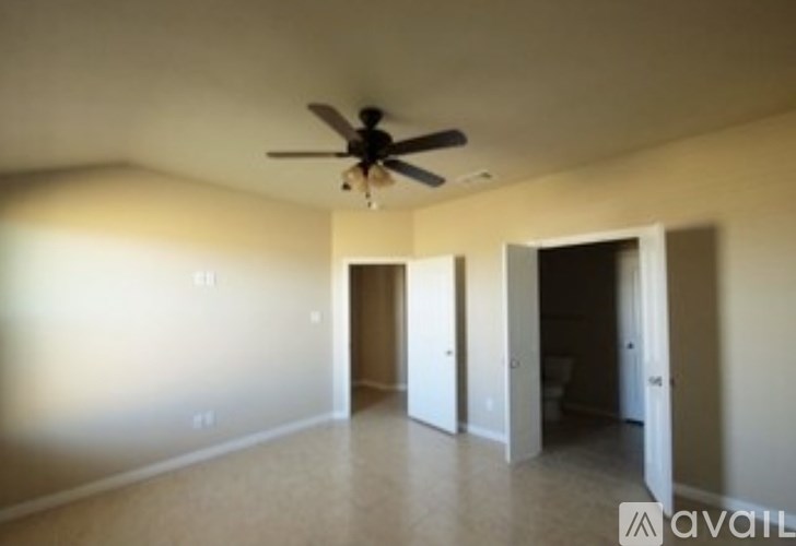A room with a ceiling fan and three doors.