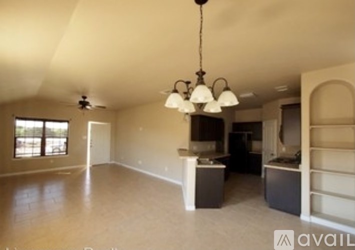 A large empty room with a chandelier hanging from the ceiling.