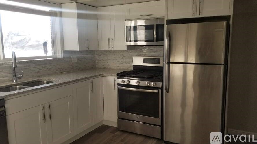 A modern kitchen with stainless steel appliances and white cabinets.