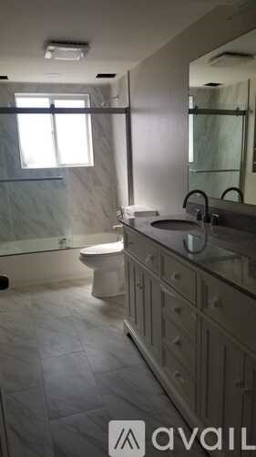 A bathroom with a toilet, sink, and shower.