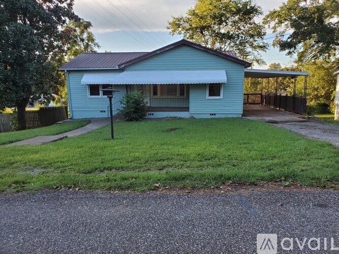 A blue house with a white roof and a grey driveway.