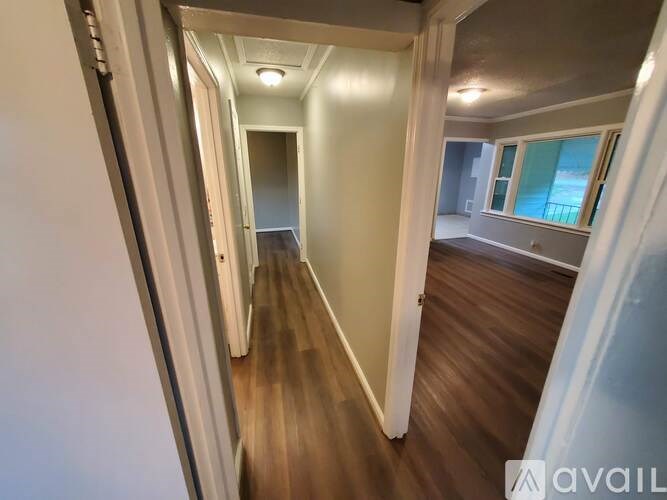 A long hallway with wooden floors and white walls.