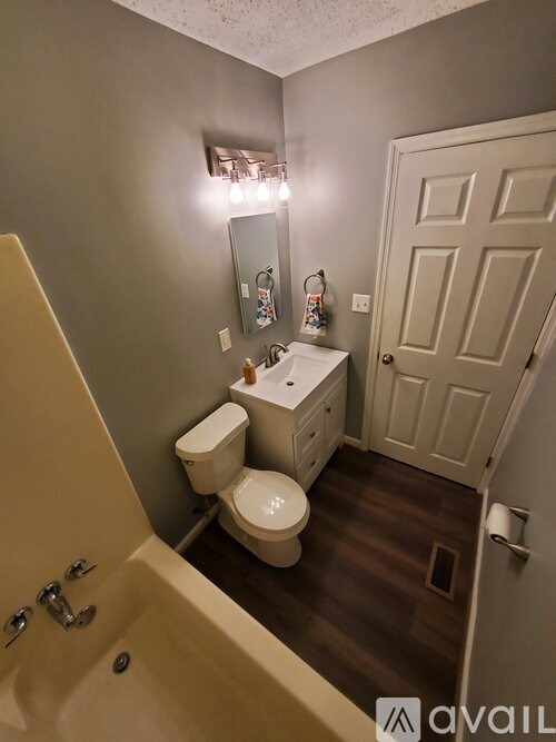 A bathroom with a toilet, sink, and bathtub.
