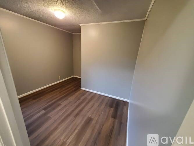 A room with wooden flooring and white walls.