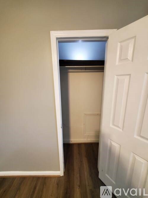 A white door with a window above it in a room with wooden floors.