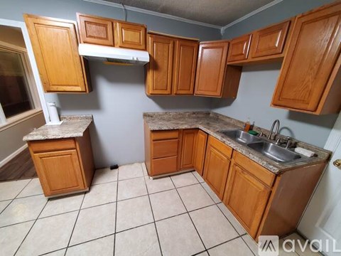 A kitchen with wooden cabinets and a sink.