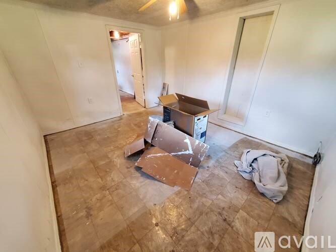 A room with a box and a bag on the floor.