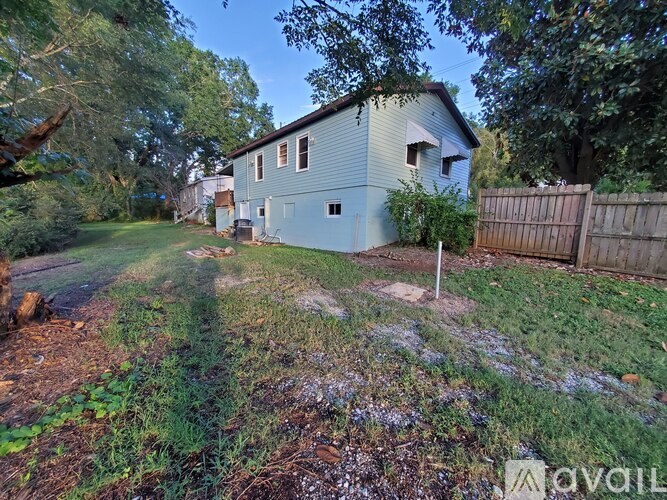 A house with a fence and trees in the background.