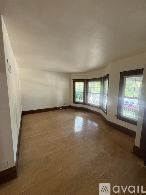 A room with wooden flooring and white walls.