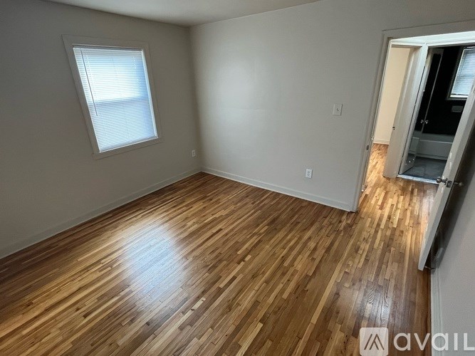 A room with wooden flooring and a window.