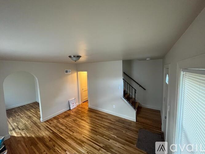 A room with wooden floors and a staircase.