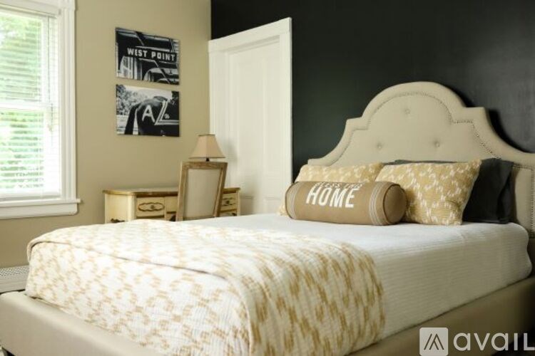A bed with a white headboard and a white comforter with a pattern on it.