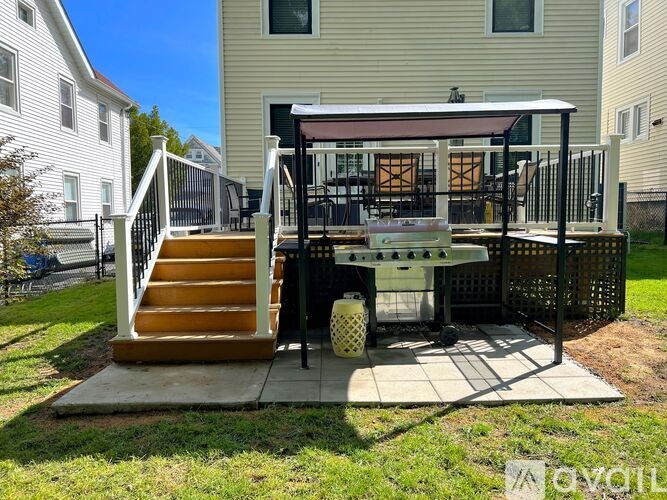A patio with a table and chairs is in front of a house.