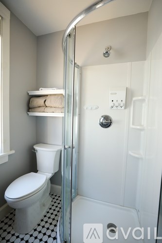 A white toilet sits next to a glass shower door.