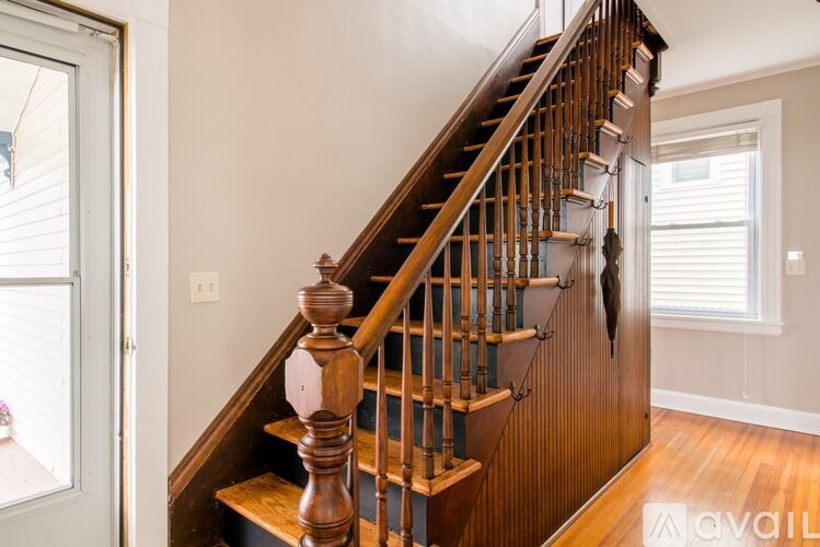 A wooden staircase with a balustrade and a wooden handrail.