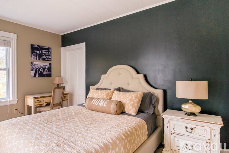 A bedroom with a bed, nightstand, and lamp.