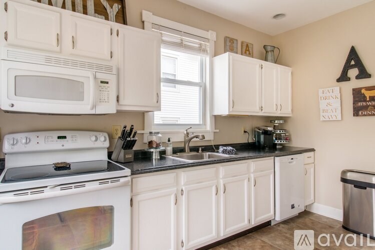 A kitchen with white appliances and cabinets.