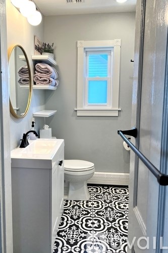 A bathroom with a toilet, sink, and a mirror.
