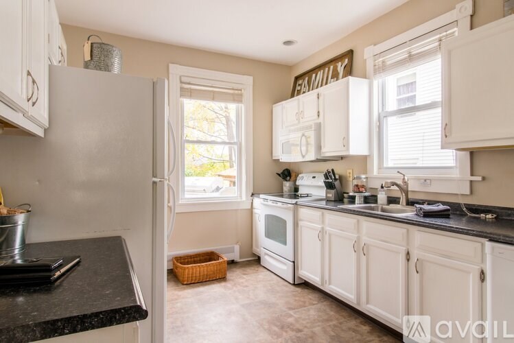 A kitchen with white cabinets and a black countertop.