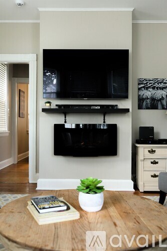 A living room with a flat screen TV mounted on the wall above a wooden coffee table.