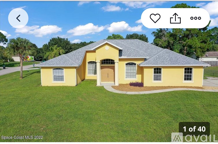 A yellow house with a grey roof is shown in the image.