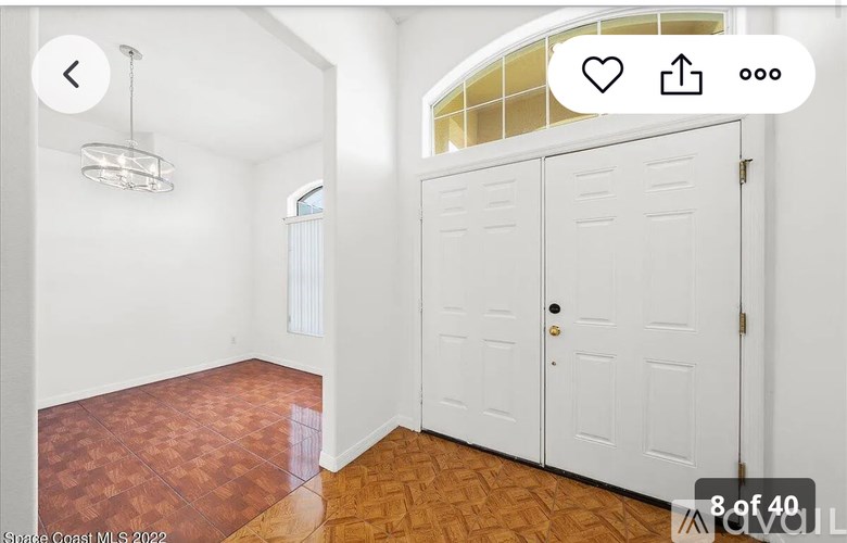 A room with a white door and a chandelier.