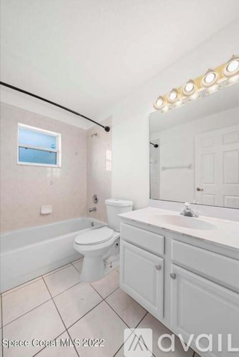A bathroom with a toilet, sink, and mirror.