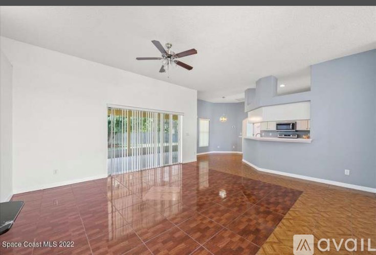 A spacious room with a ceiling fan and a wooden floor.