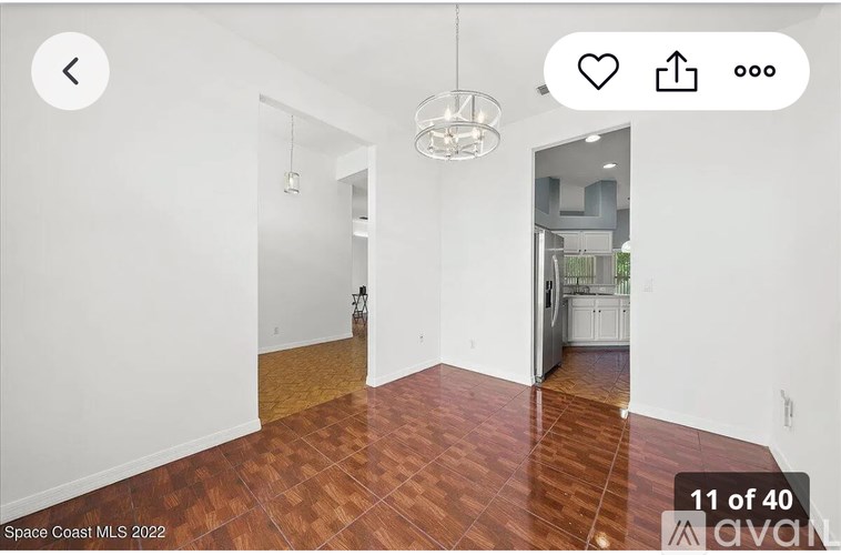 A room with wooden flooring and white walls.