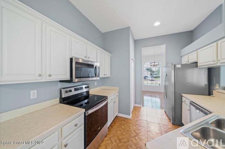 A kitchen with white cabinets and a black stove top oven.