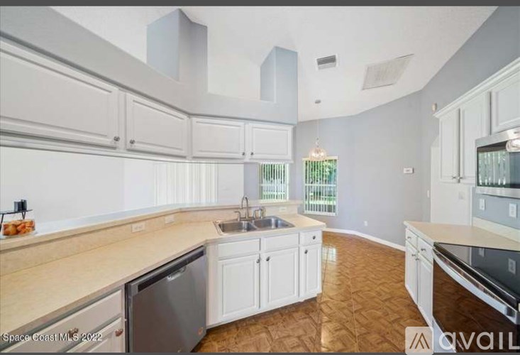 A kitchen with white cabinets and a wooden countertop.