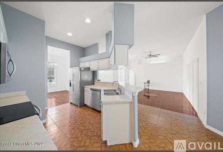 A kitchen with a tiled floor and a dishwasher.