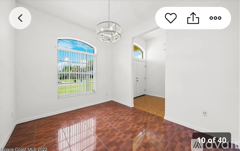 A room with a window and a wooden floor.