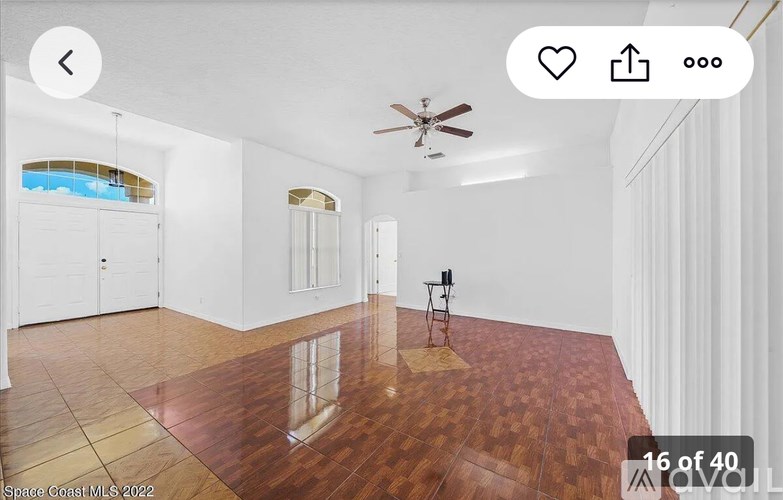 A room with wooden flooring and a ceiling fan.